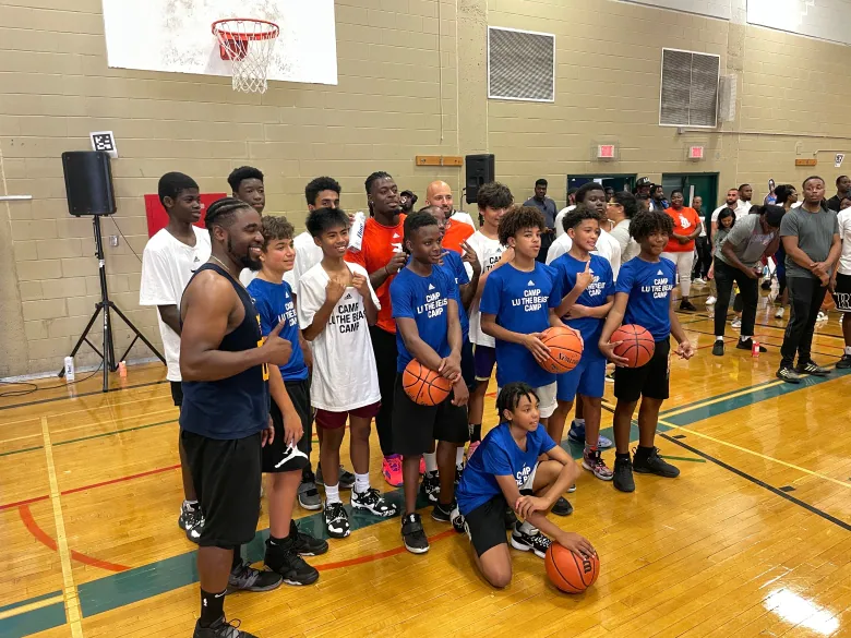 A group of teenage boys gathers to pose alongside the NBA player.