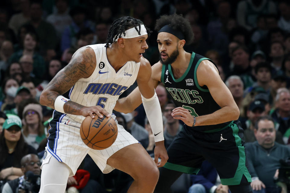 Orlando Magic forward Paolo Banchero drives against Boston Celtics guard Derrick White during the first half of an NBA basketball game, Sunday, Dec. 18, 2022, in Boston. (AP Photo/Mary Schwalm)