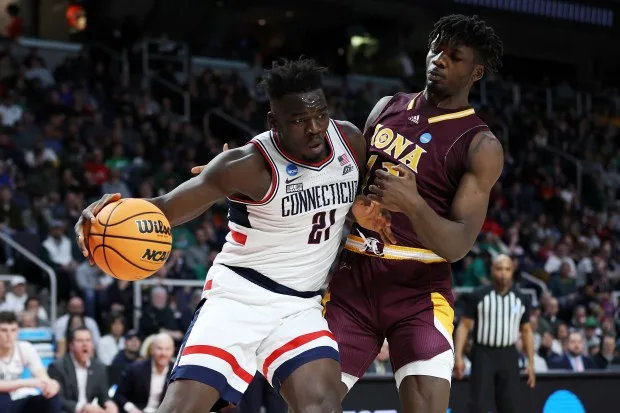 ALBANY, NEW YORK - MARCH 17: Nelly Junior Joseph #13 of the Iona Gaels defends Adama Sanogo #21 of the Connecticut Huskies in the second half during the first round of the NCAA Men's Basketball Tournament at MVP Arena on March 17, 2023 in Albany, New York. (Photo by Patrick Smith/Getty Images) ** OUTS - ELSENT, FPG, CM - OUTS * NM, PH, VA if sourced by CT, LA or MoD **