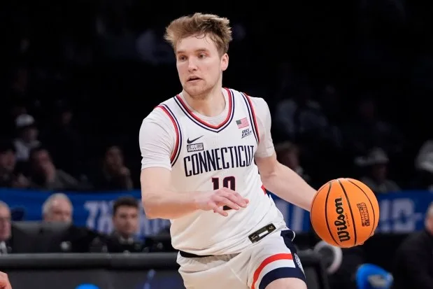 UConn's Cam Spencer (12) looks to pass during the second half of a first-round college basketball game against Stetson in the NCAA Tournament, Friday, March 22, 2024, in New York. UConn won 91-52. (AP Photo/Frank Franklin II)